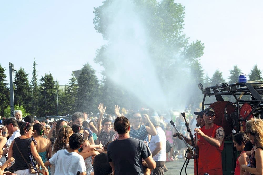 Uomini della Protezione Civile rinfrescano la folla