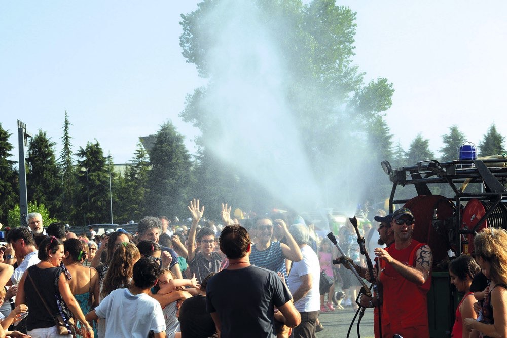 Uomini della Protezione Civile rinfrescano la folla